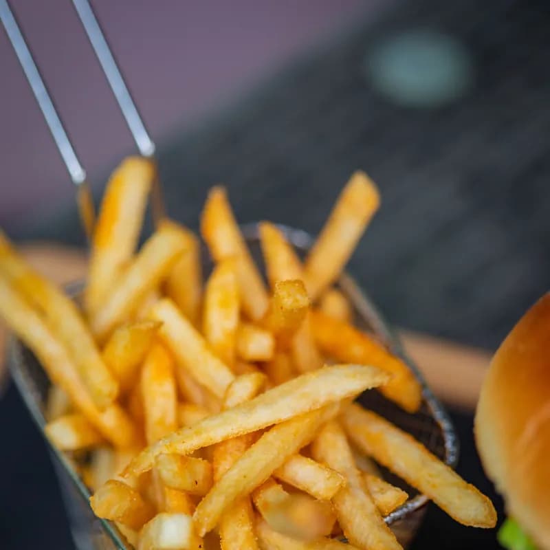 Crispy fries in a metal basket close-up, used to explain whether celiacs can eat fast-food fries