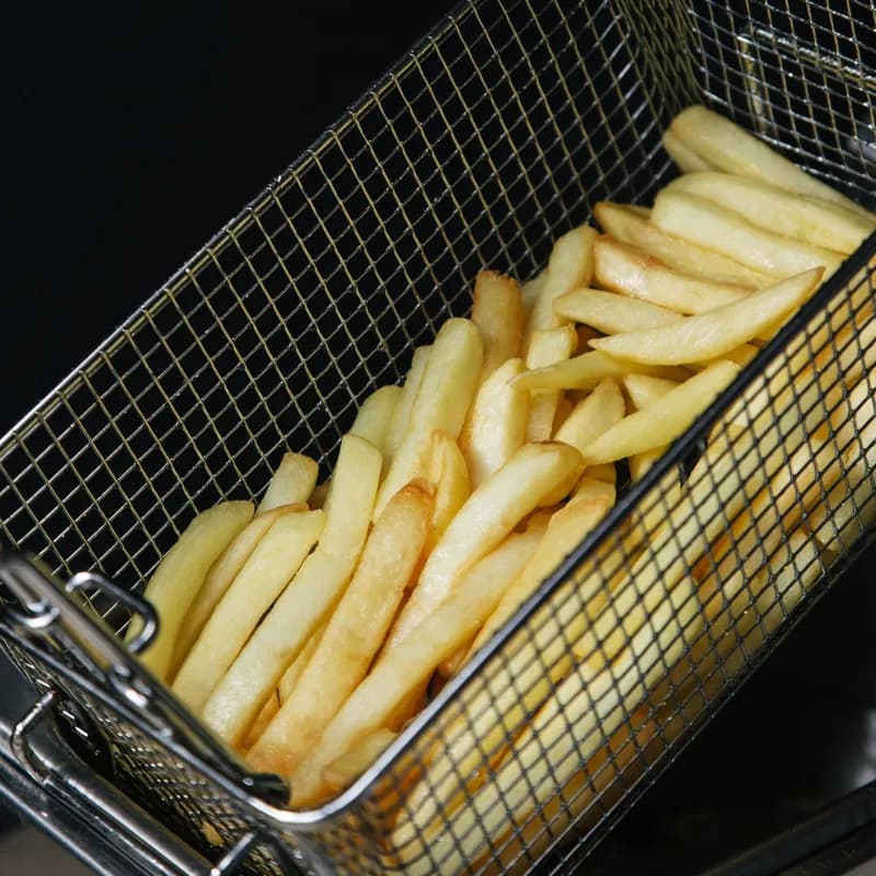 French fries in a frying basket over hot oil showing the shared fryer cross-contact risk