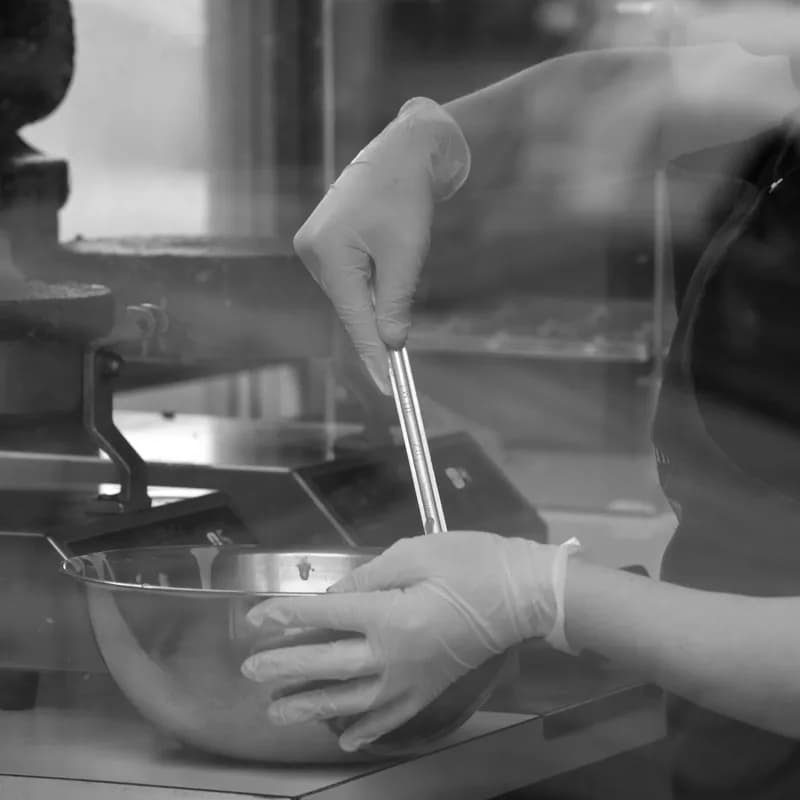 Kitchen worker in gloves preparing food in a steel bowl, a glove change helps a celiac order at Wendy's