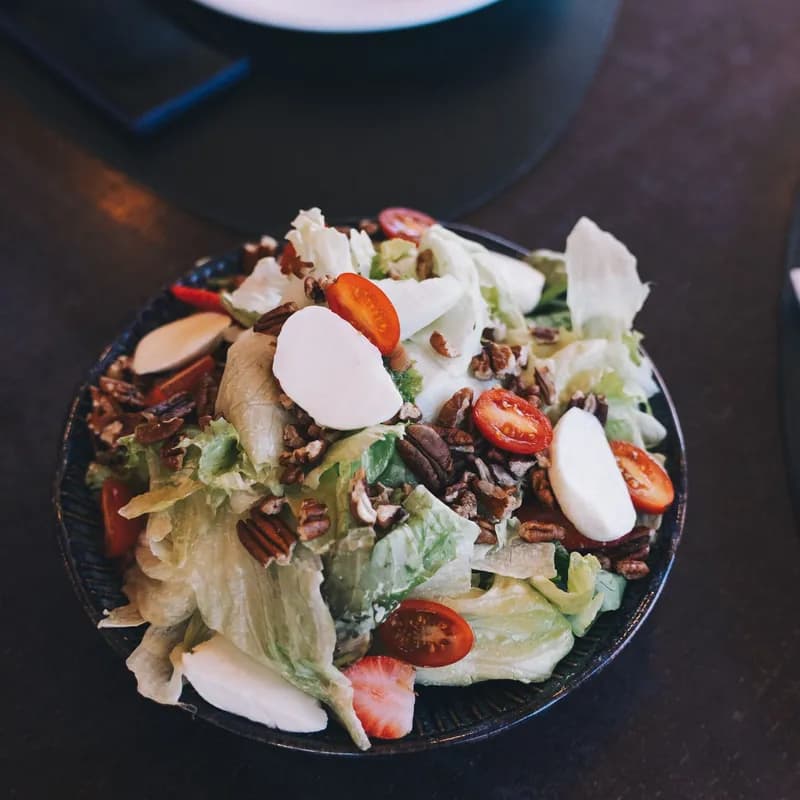 Mixed green salad with pecans and cherry tomatoes, similar to a gluten free apple pecan salad at Wendy's