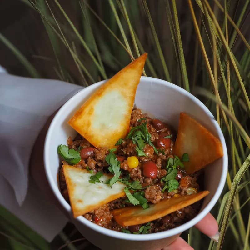 Chili con carne bowl with tortilla chips and coriander as a gluten free chili topping idea
