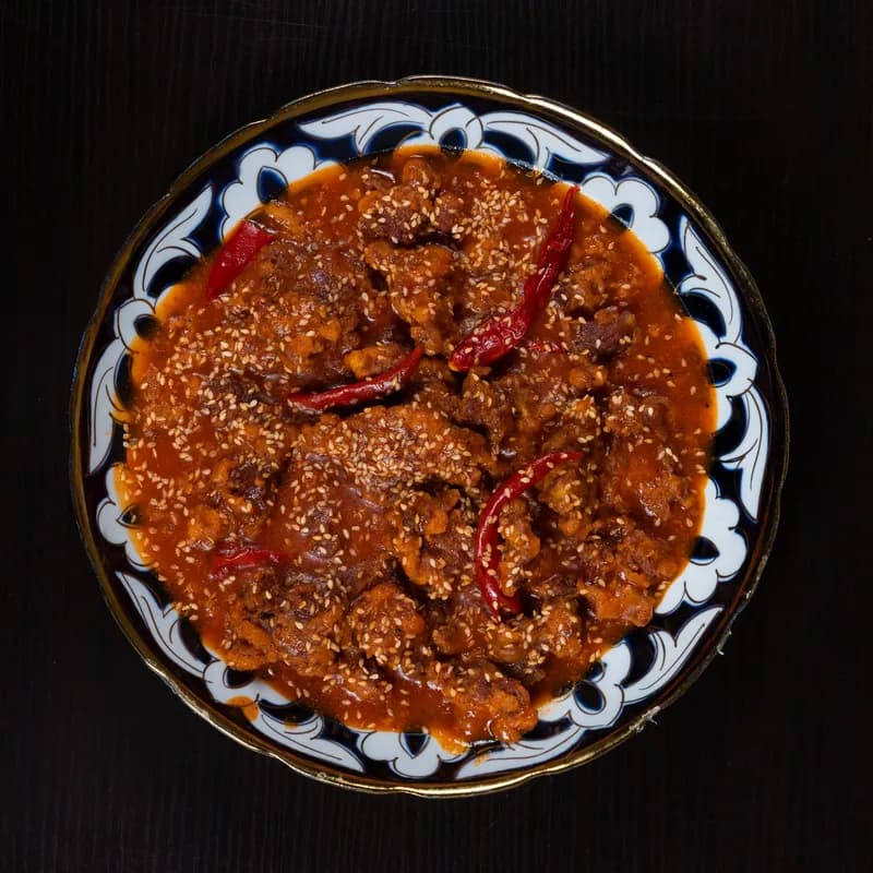 Spiced beef and tomato chili-style stew in a patterned bowl, shown for celiac friendly chili questions